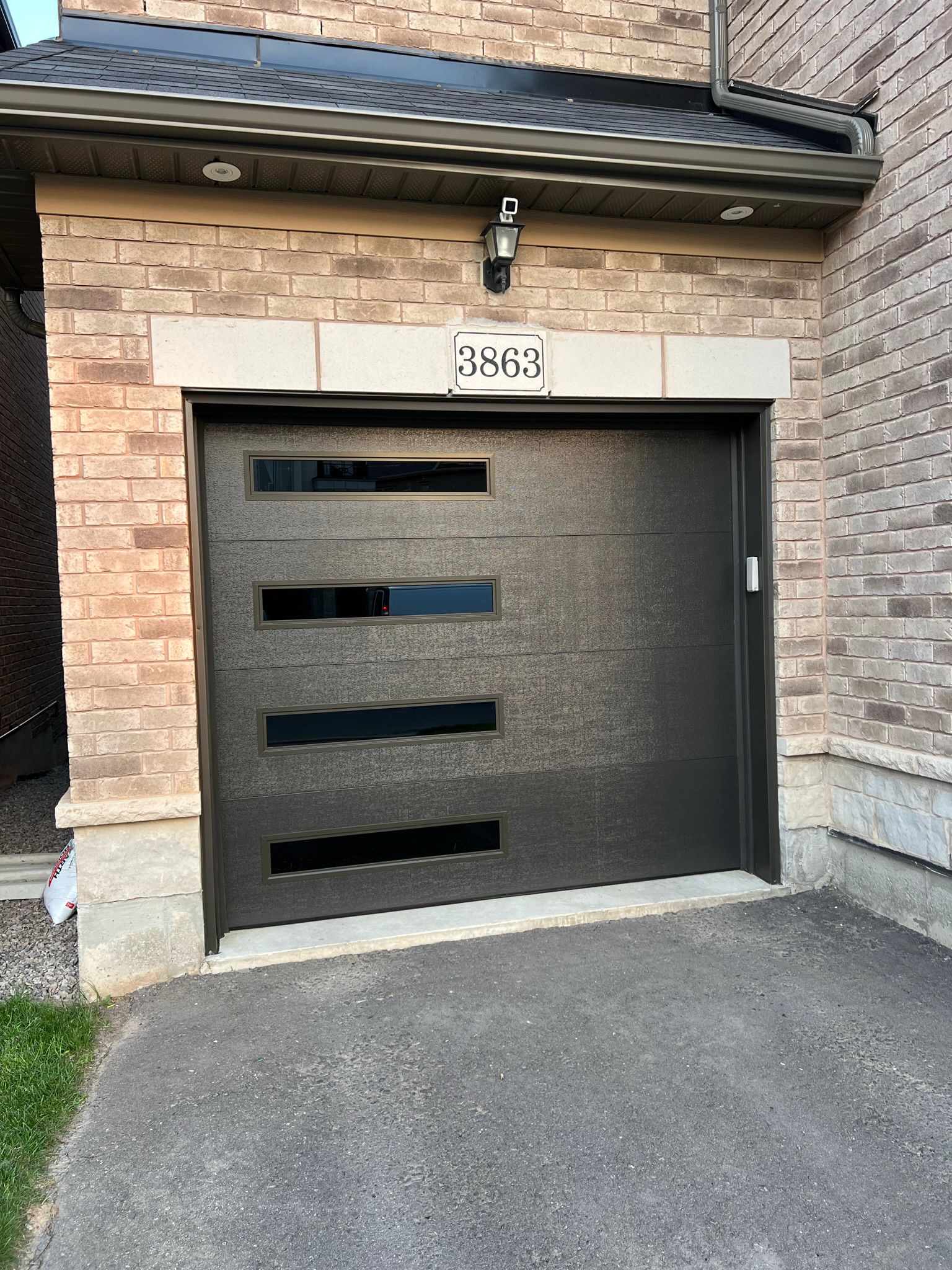Close-up of charcoal contemporary single garage door with offset horizontal glass panels at house 3863