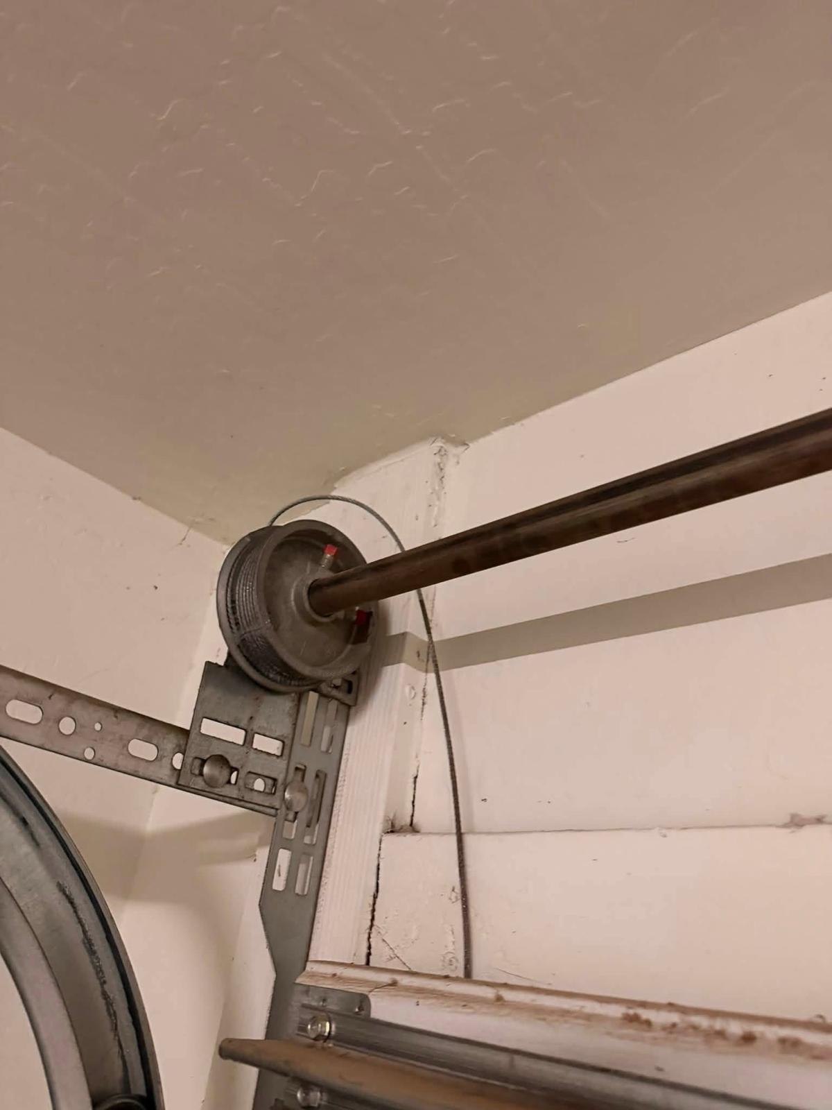 Close-up of garage door cable drum, lift cable, and torsion shaft assembly - LTA field photo